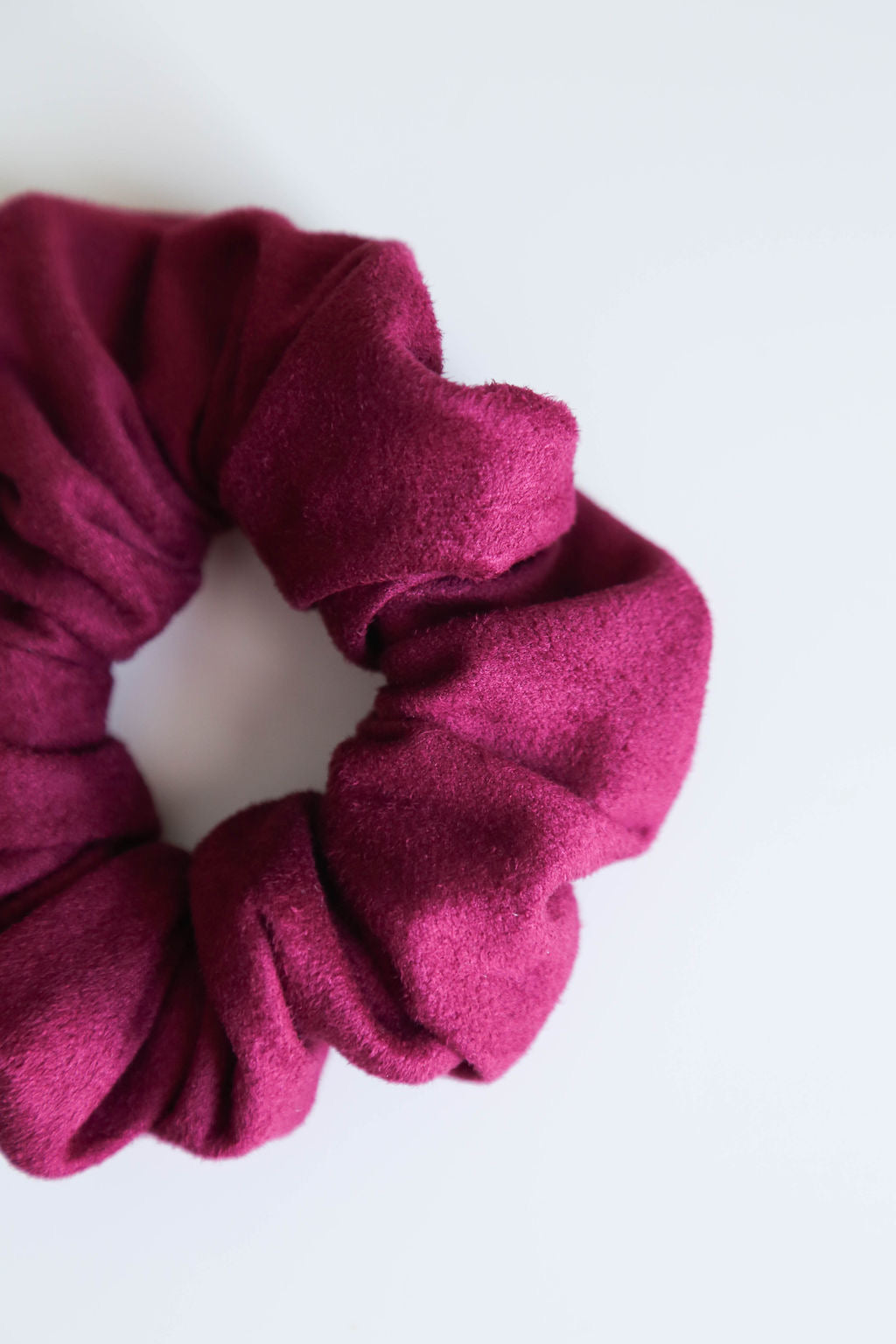 Close-up of the Suede Berry Scrunchie, featuring a soft suede finish in a vibrant berry hue.