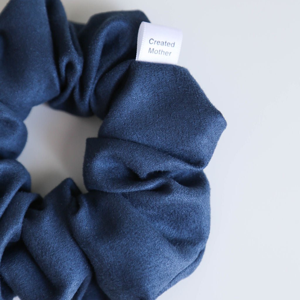 Close-up of the Shadow Blue Suede Scrunchie, featuring a luxurious suede finish in a tranquil blue hue.