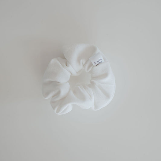 White scrunchie on a light gray background