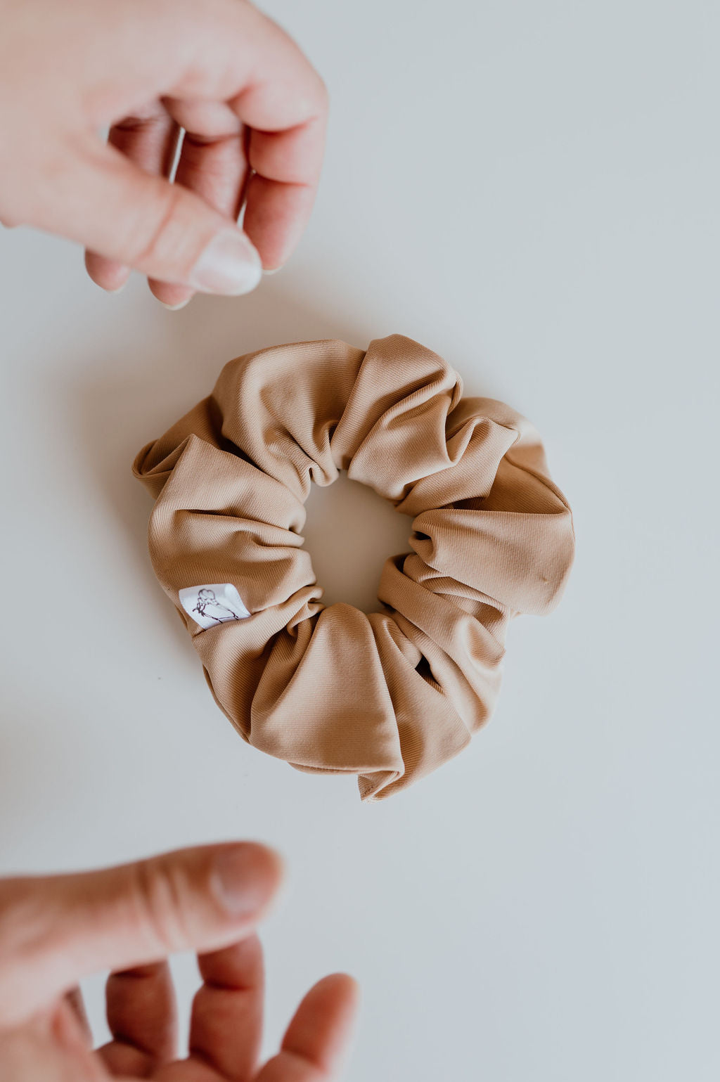 Tan scrunchie made of spandex and nylon blend