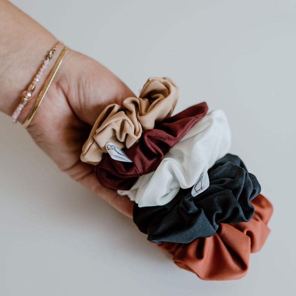 Collection of water-repellent swim scrunchies in neutral colours.